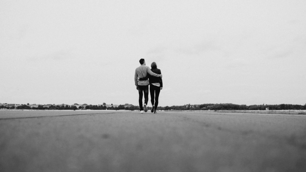 man and woman walking together with their arms around each other