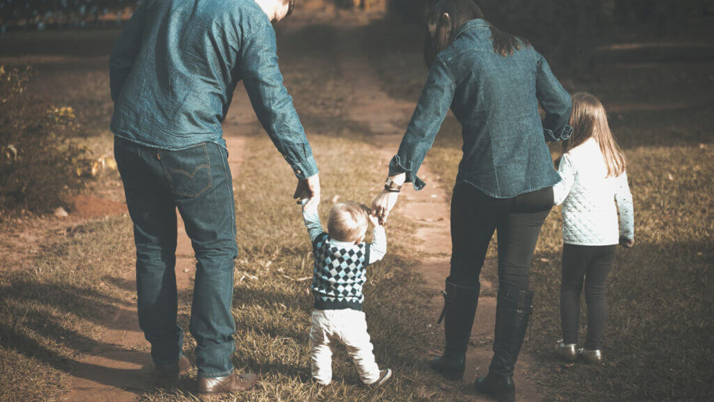 a father and mother hold the hands of a small child walking between them, why men and women need each other