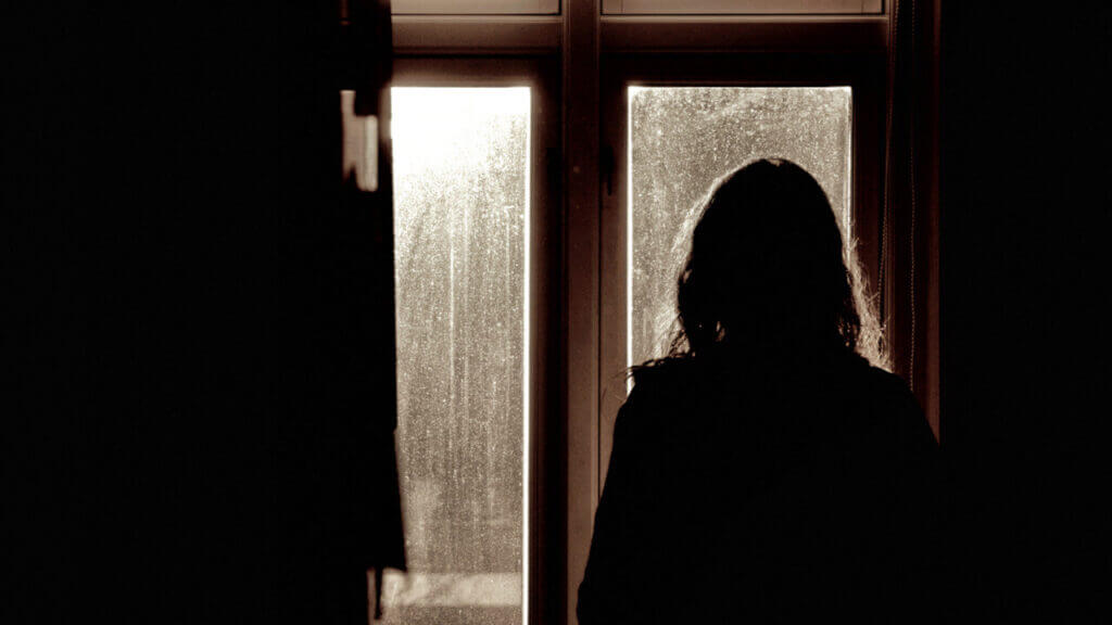 back of a woman looking out of a window