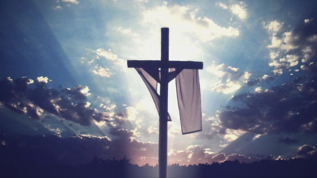 an empty cross with a piece of fabric draped across in front of a sunny sky, Catholic Psychology