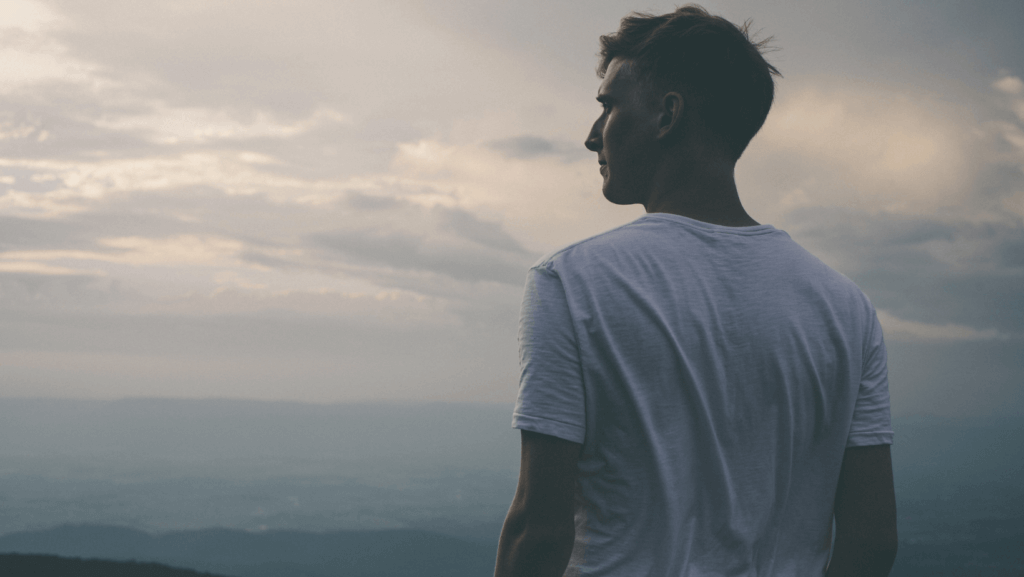 a young man looking out at the view to his left