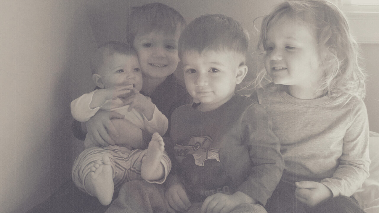 a black and white picture of four small children sitting together posing, motherhood and mindfulness