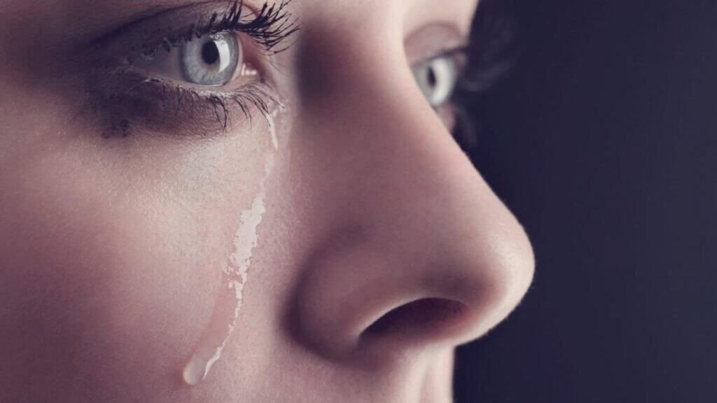 closeup of a woman with a tear running down her cheek gender differences