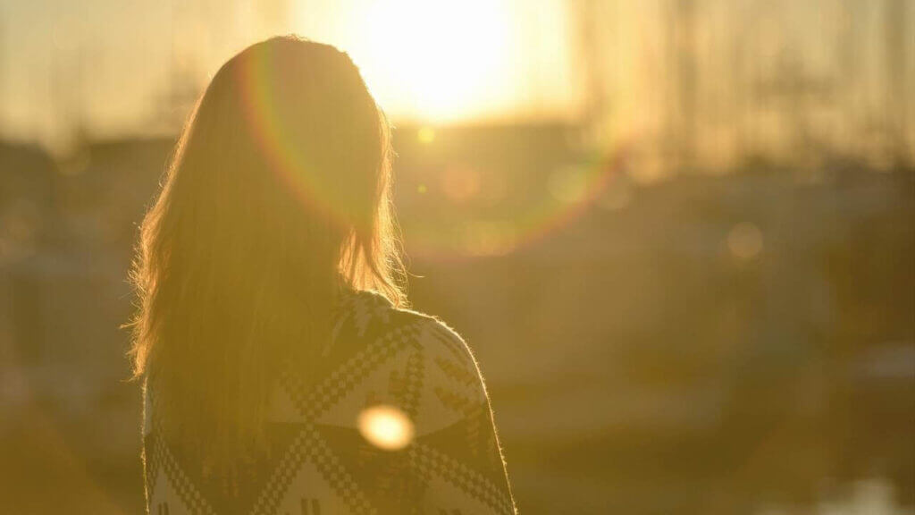 the back of a woman who is staring into the sun behind her, healing through Catholic mindfulness