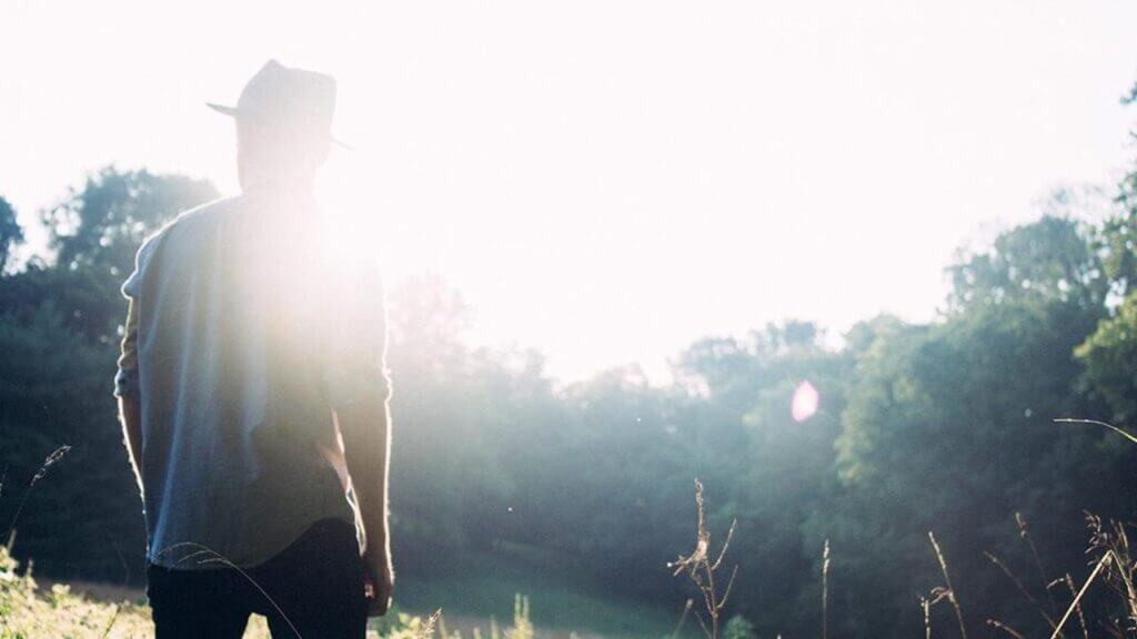 back of man looking at meadow and field catholic psychology