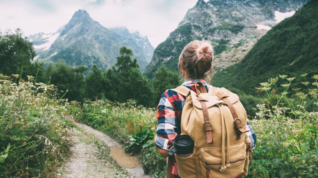 woman with backpack on a trail going through a mountain range, the female brain